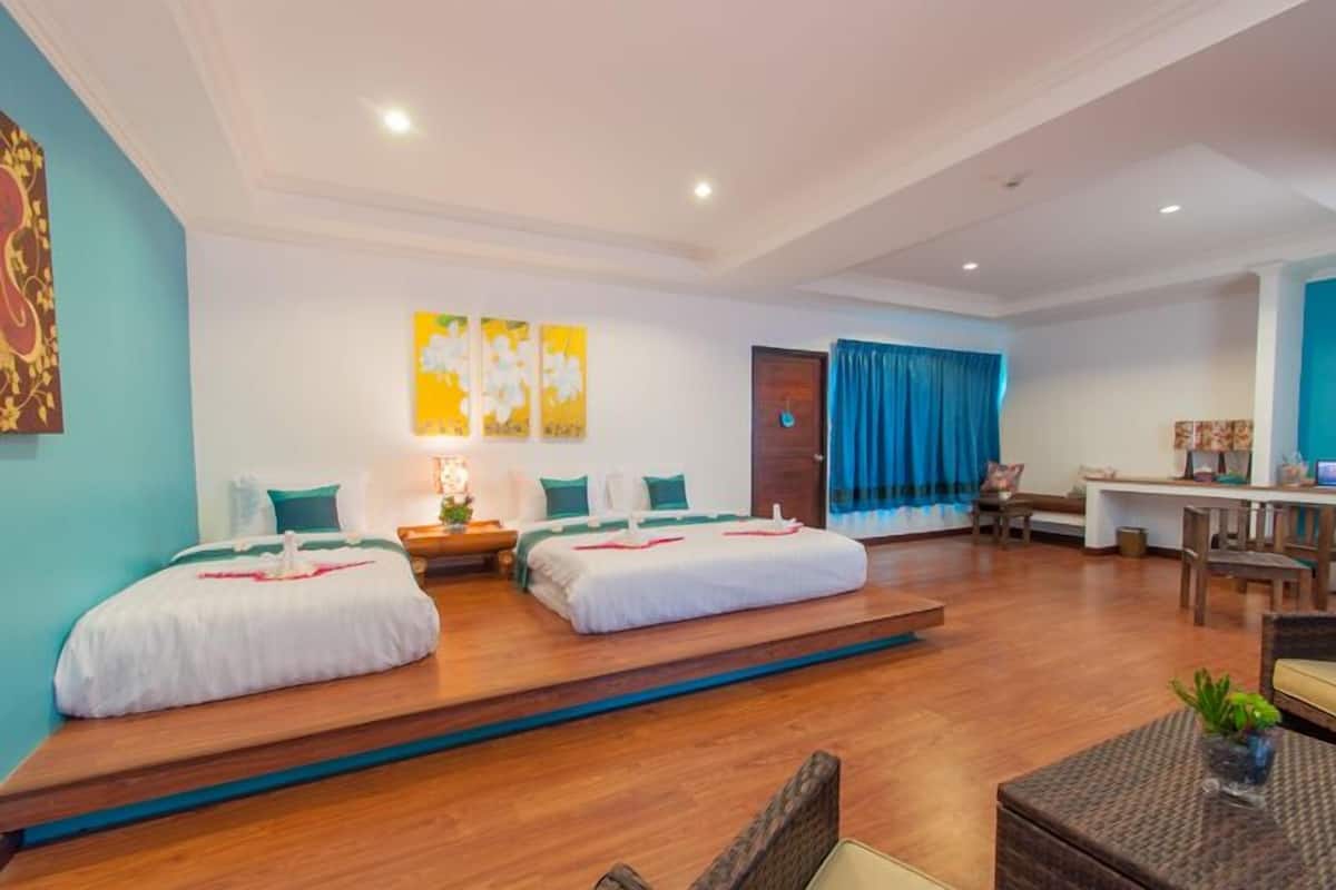 Une chambre d’hôtel avec deux lits, un bureau et un coin salon.