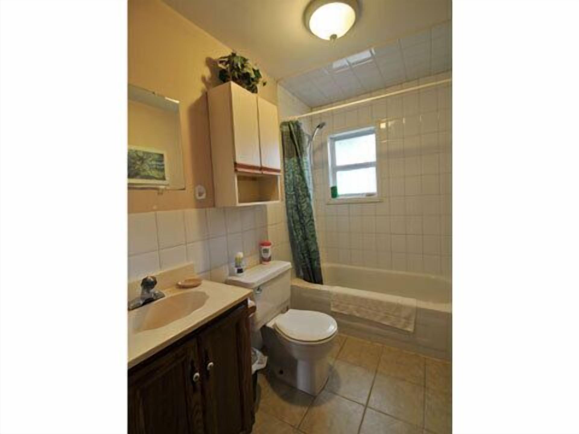Ein Badezimmer mit Toilette, Waschbecken und Duschbereich.