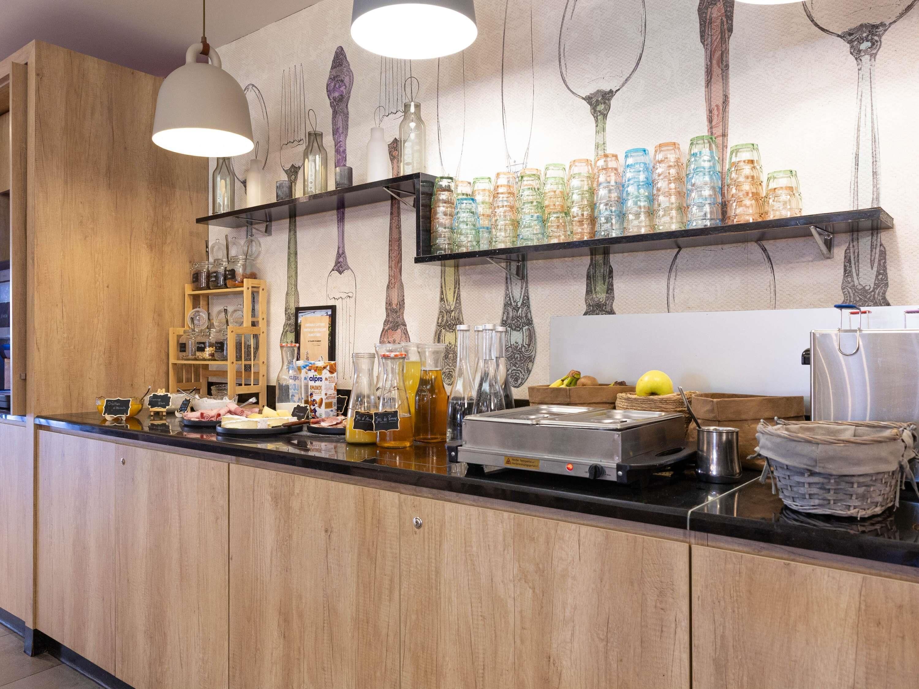 Una encimera de cocina con varios recipientes de vidrio, una cafetera y una cesta de frutas.