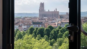 A view of a historic building with a tall tower, surrounded by a densely packed urban area with traditional architecture. - Ibis Styles Albi Centre Le Theatro (Albi)