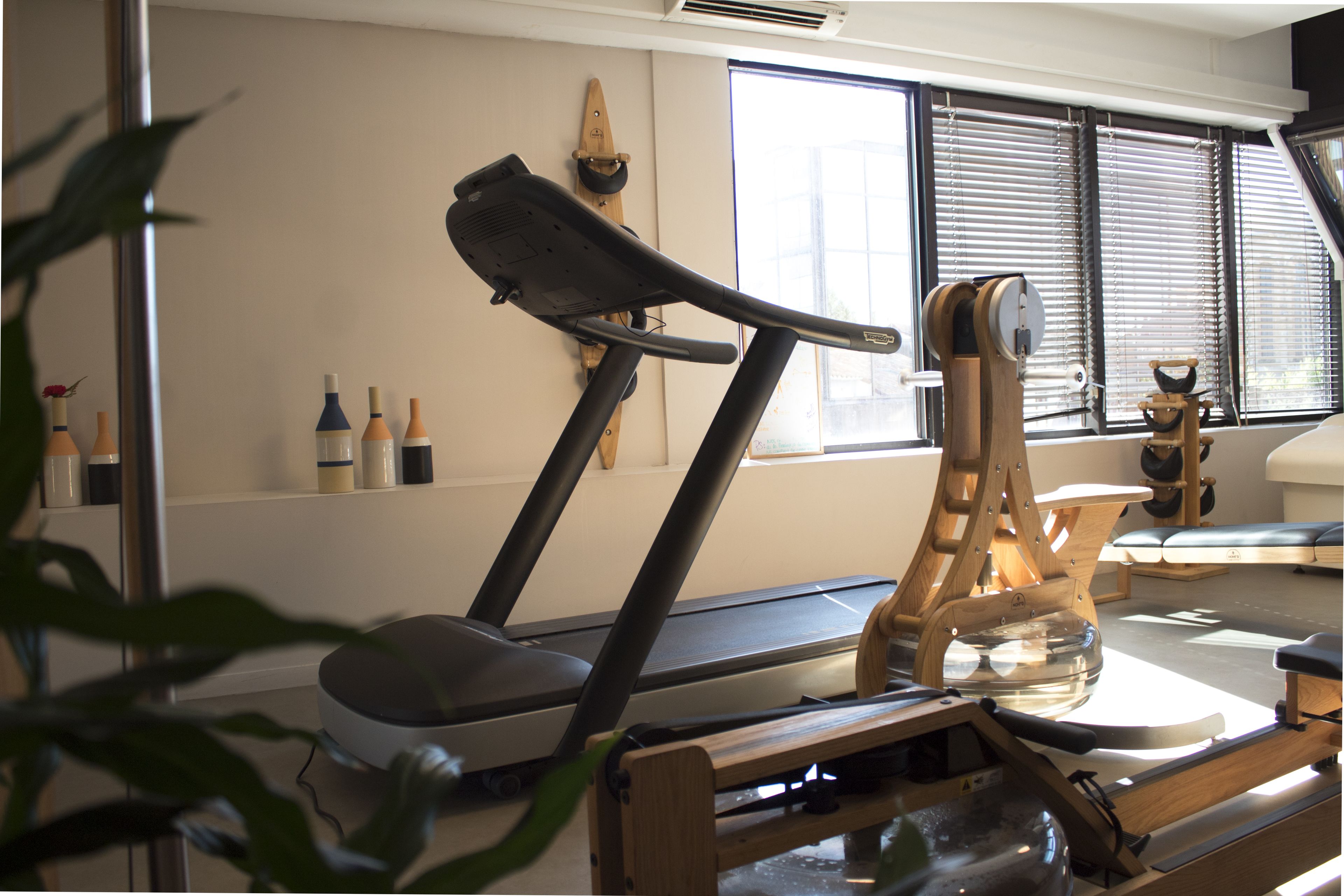 Un gimnasio en casa con cinta de correr, bicicleta estática y máquina de remo.