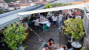 An outdoor patio area with tables and chairs, surrounded by greenery and a cityscape view. - Ibis Styles Albi Centre Le Theatro (Albi)