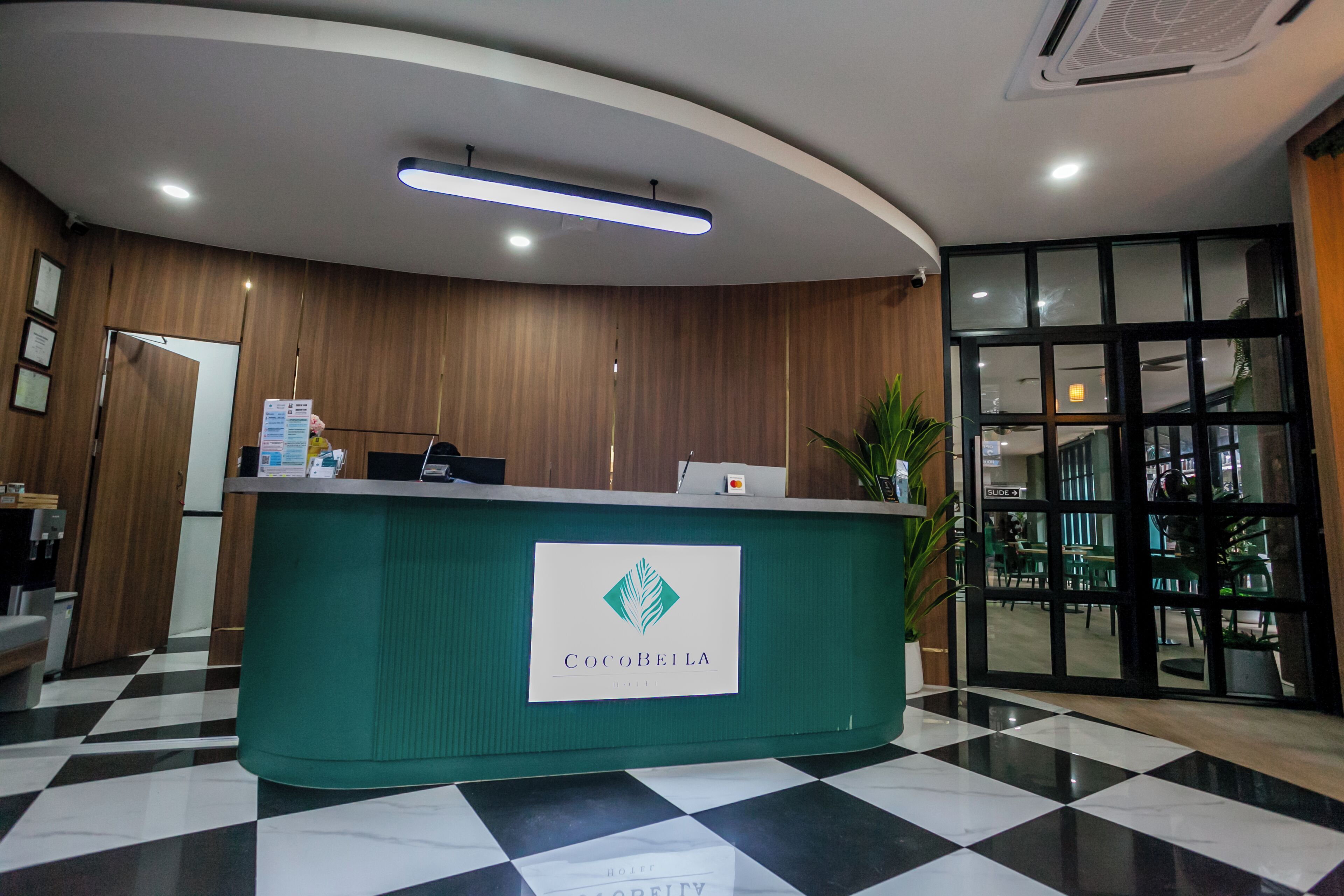 A reception desk with a logo, a checkered floor, and a large window.