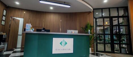 A reception desk with a logo, a checkered floor, and a large window.