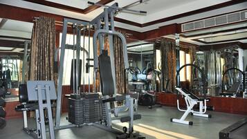 A gym with various exercise equipment, large mirrors, and a wooden interior.