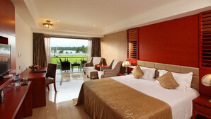 Habitació d'hotel amb llit, escriptori, televisió i balcó amb vista al mar.