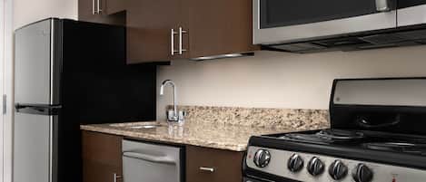 A modern kitchen with stainless steel appliances, granite countertops, and wooden cabinets.