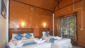 A hotel room with two beds, each with white linens and blue pillows, a wooden headboard, and a large window with curtains. - Lanta Sunny House (Ko Lanta)