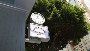 A clock and a sign for Bagel & Coffee T.O. Hotel café. - TO Hotel Chengde (Taipei)
