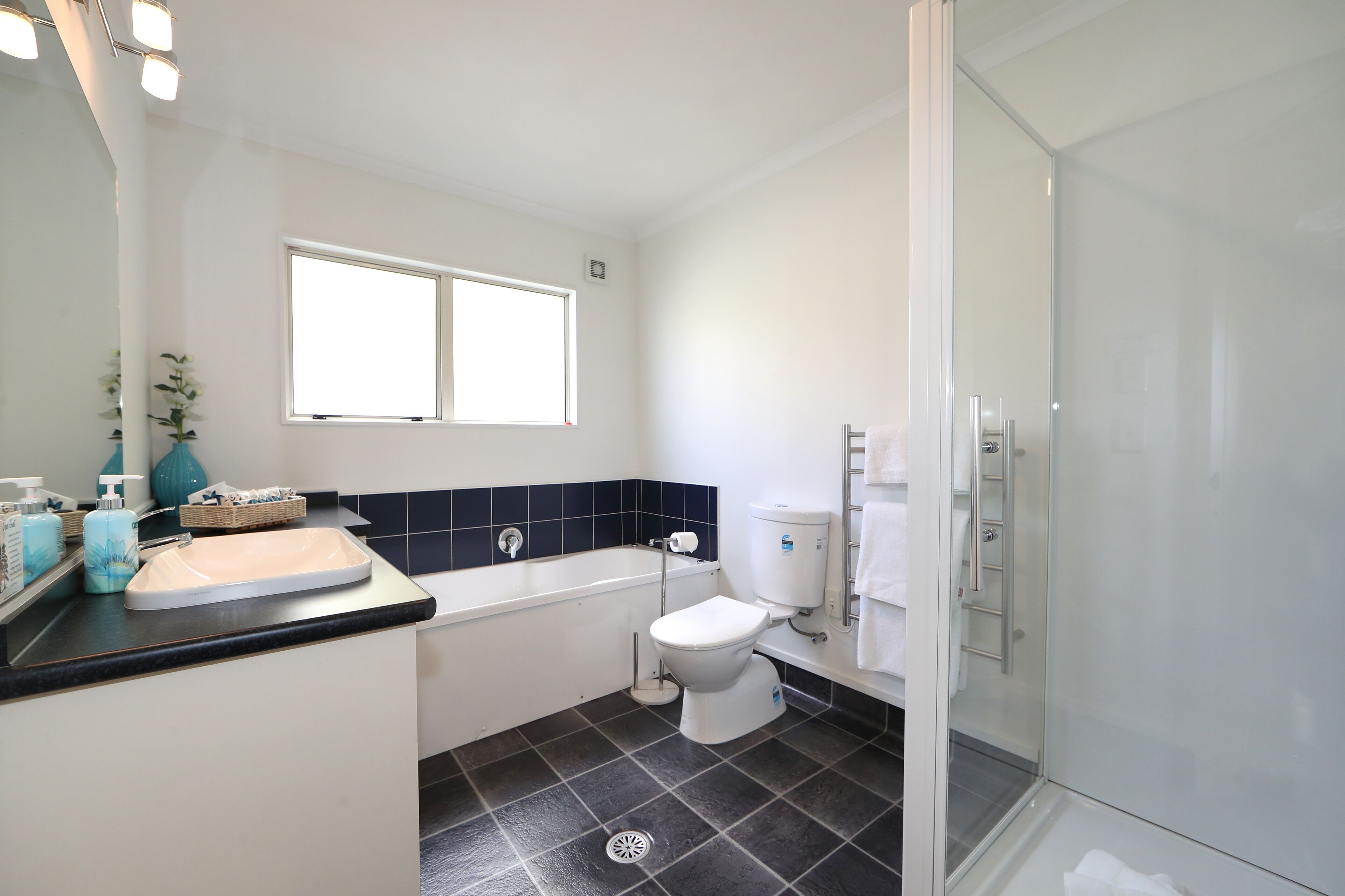 Un baño moderno con bañera, inodoro y cabina de ducha de vidrio.