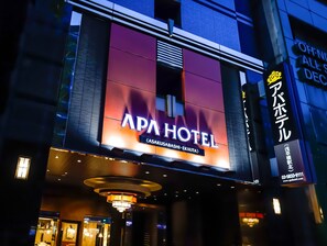 L’extérieur de l’hôtel APA présente une enseigne bien visible indiquant son nom et son emplacement.