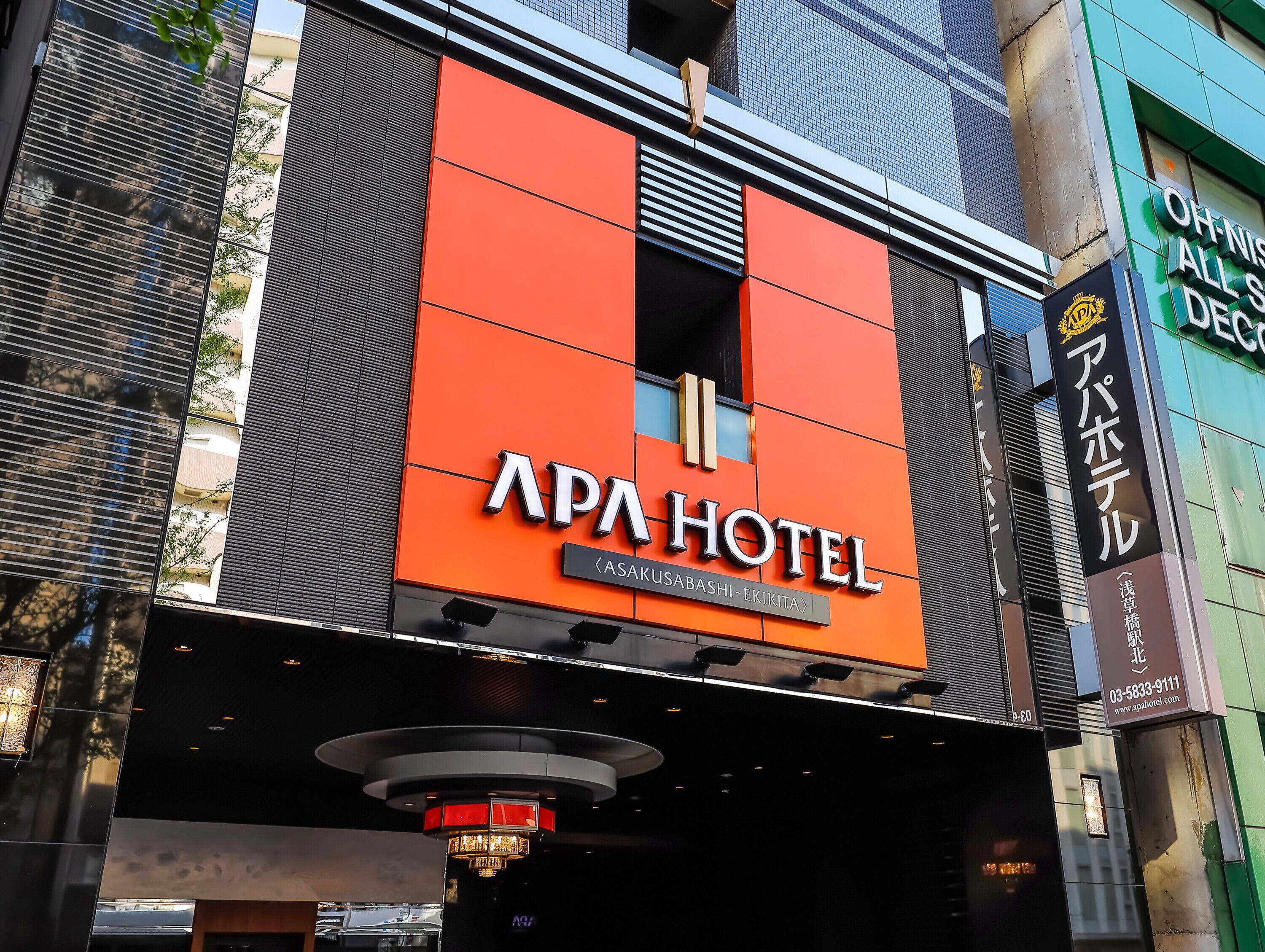 A hotel sign with the name "APA HOTEL" and a location tag "Asakusa, Tokyo".