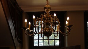 Ein prachtvoller Eingangsbereich mit einer Chandelüster, einer Holztür und Blick auf einen üppigen Garten.