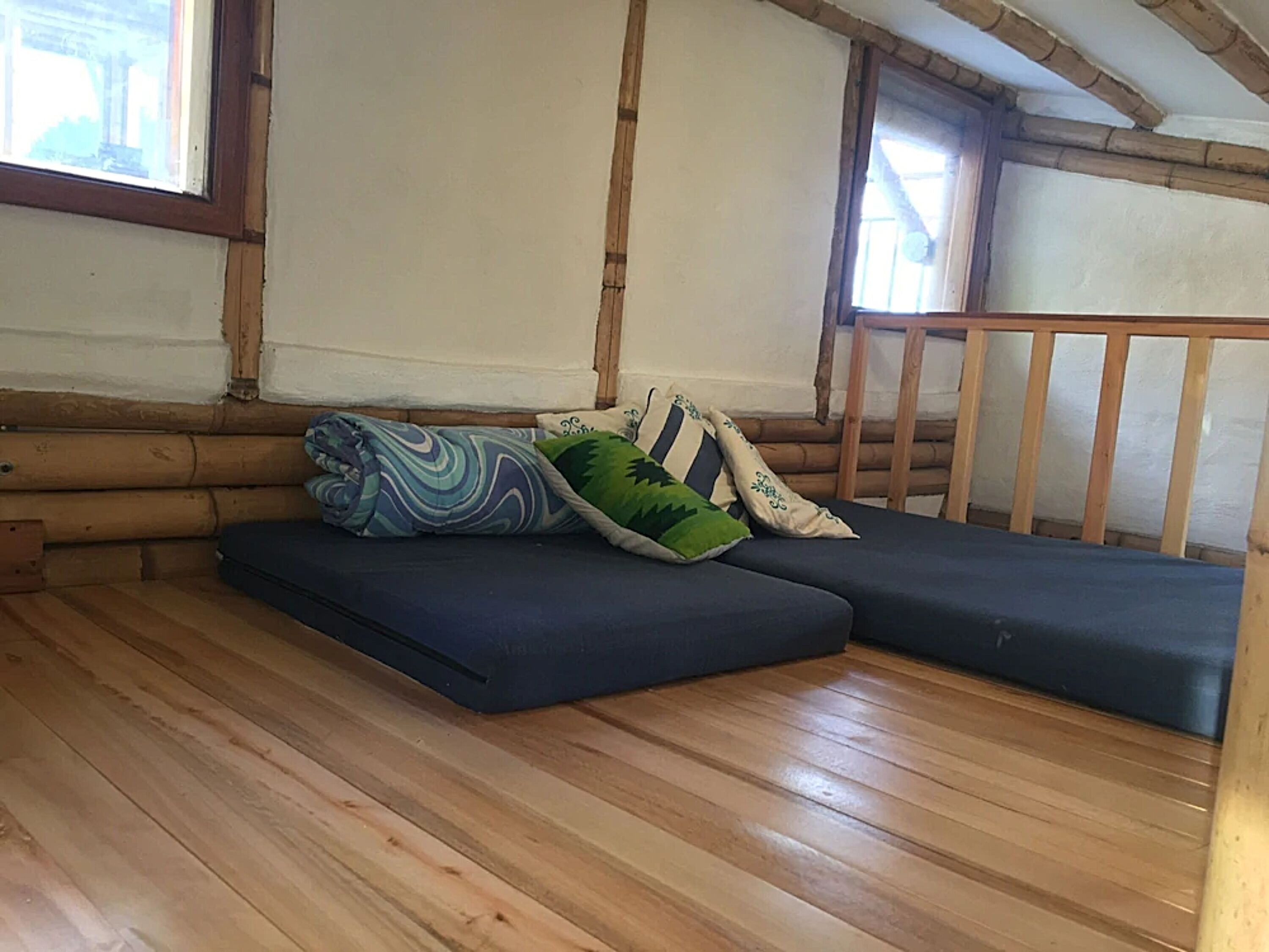 Una habitación acogedora con suelos de madera, un sofá y una ventana.