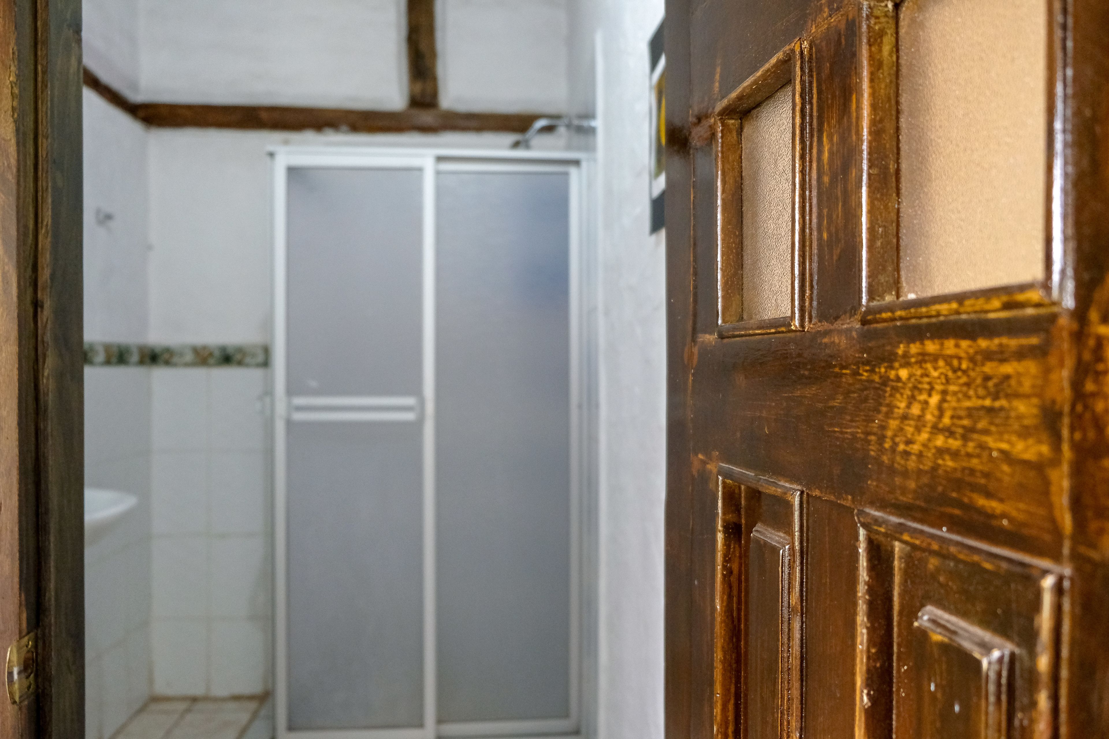 A bathroom with a white sink, a white toilet, and a shower enclosure.