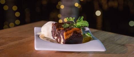 A dessert on a white plate with a blurred background of lights.