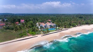 A coastal resort with multiple buildings, a beach, and a clear view of the ocean. - Sri Sharavi Beach Villas & Spa (Thalaramba)