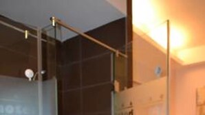 Une salle de bain moderne avec une douche à parois de verre, un lavabo blanc et un porte-serviettes.