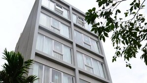 Un immeuble à plusieurs étages doté d’une architecture moderne, caractérisé par une série de fenêtres et de balcons.
