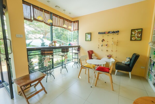 Une pièce confortable avec un balcon, un coin repas et un espace salon avec une table et des chaises.
