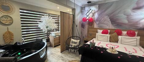 Un cuarto de spa con una silla de masaje, una camilla de masaje y una camilla de masaje montada en la pared. Se ven tres camillas de masaje con toallas.