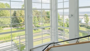 A staircase with a view of a green landscape and a body of water. - Rannahotell (Parnu)