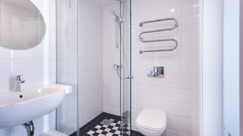 Un bagno moderno con doccia vetrata, lavandino bianco e water.