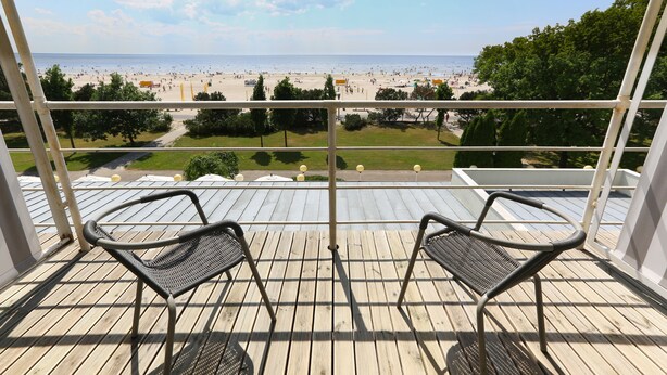 A balcony with two chairs overlooking a beach. - Rannahotell (Parnu)