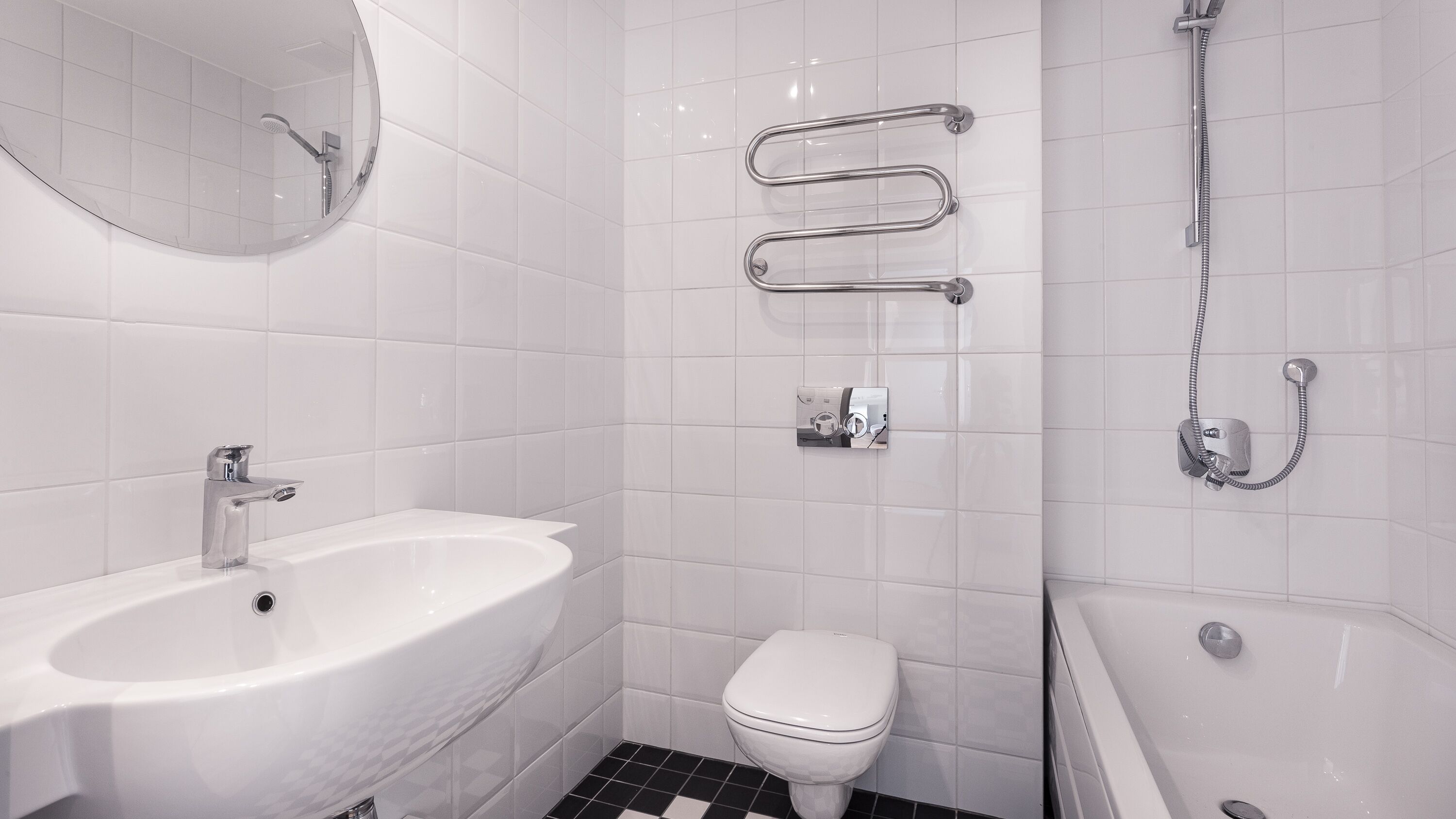 A modern bathroom with a white sink, toilet, and bathtub.
