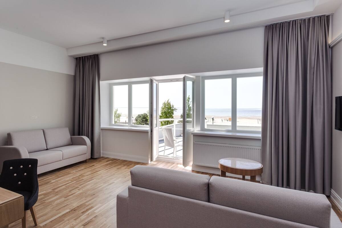 A modern living room with a sofa, a chair, a small table, and a TV.