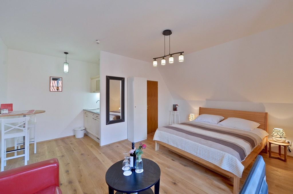A modern bedroom with a wooden bed, a small desk, and a chair.