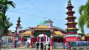 A multi-tiered pagoda-style building with a green dome and red and yellow roof.