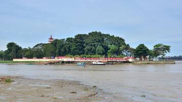 A riverside view with a bridge, boats, and a pagoda.