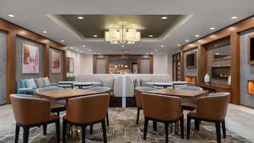 Un comedor moderno con una disposición central de asientos, varias mesas y sillas.