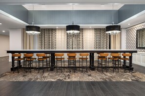 A conference room with a long table, multiple chairs, and three pendant lights.