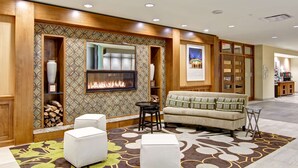 Un hall d’entrée avec une cheminée, un coin salon et une décoration en bois.