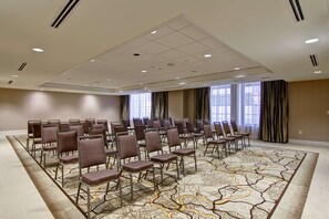 A conference room with rows of chairs, large windows, and a patterned carpet. - Homewood Suites by Hilton Cincinnati-Downtown (Cincinnati)