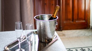 Una bandeja con tres copas y una botella de champán sobre una mesa cerca de una puerta que ofrece vistas a edificios.