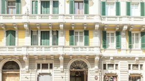 Un edificio de varios pisos con estilo arquitectónico clásico, que presenta ventanas y balcones simétricos.