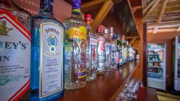 Un bancone bar con diverse bottiglie di liquore, tra cui gin Bombay Sapphire e Gordo.