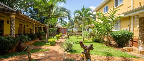 Un patio con un sendero de piedra, palmeras y una estatua.