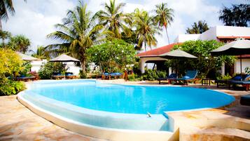 Een buitenzwembad, parasols bij het zwembad en ligstoelen