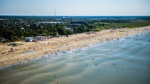 An aerial view of a beach with numerous people, a sandy shore, and a clear sky. - Hedon SPA & Hotel (Parnu)
