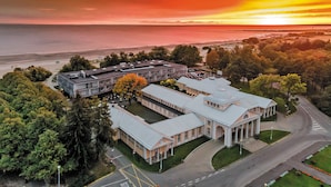 An aerial view of a hotel with a large building, a parking area, and a beach in the background. - Hedon SPA & Hotel (Parnu)