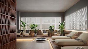A modern living room with a fireplace, sofas, and potted plants. - Hedon SPA & Hotel (Parnu)