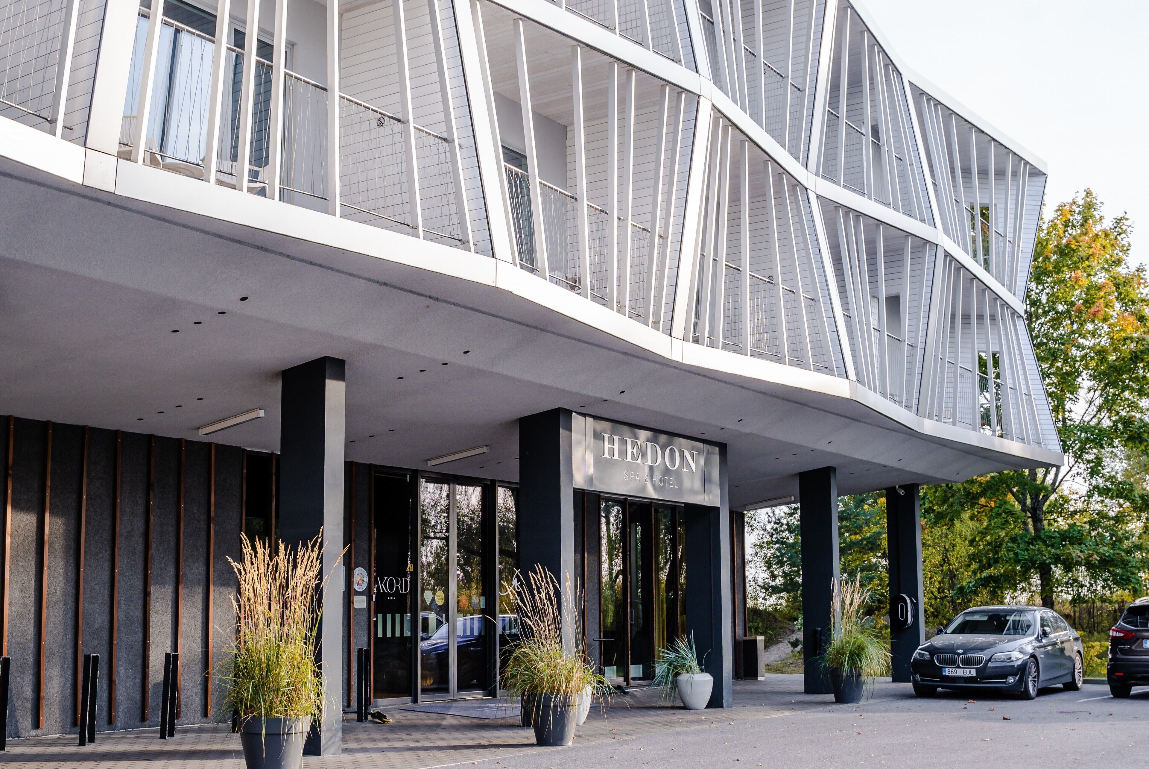 A modern hotel with a curved facade, large glass windows, and a prominent entrance.