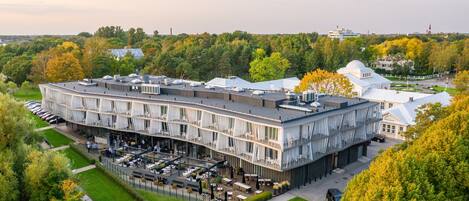 A multi-story hotel with outdoor seating areas and a parking lot.