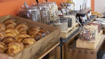 A buffet with various baked goods and jars of spreads.