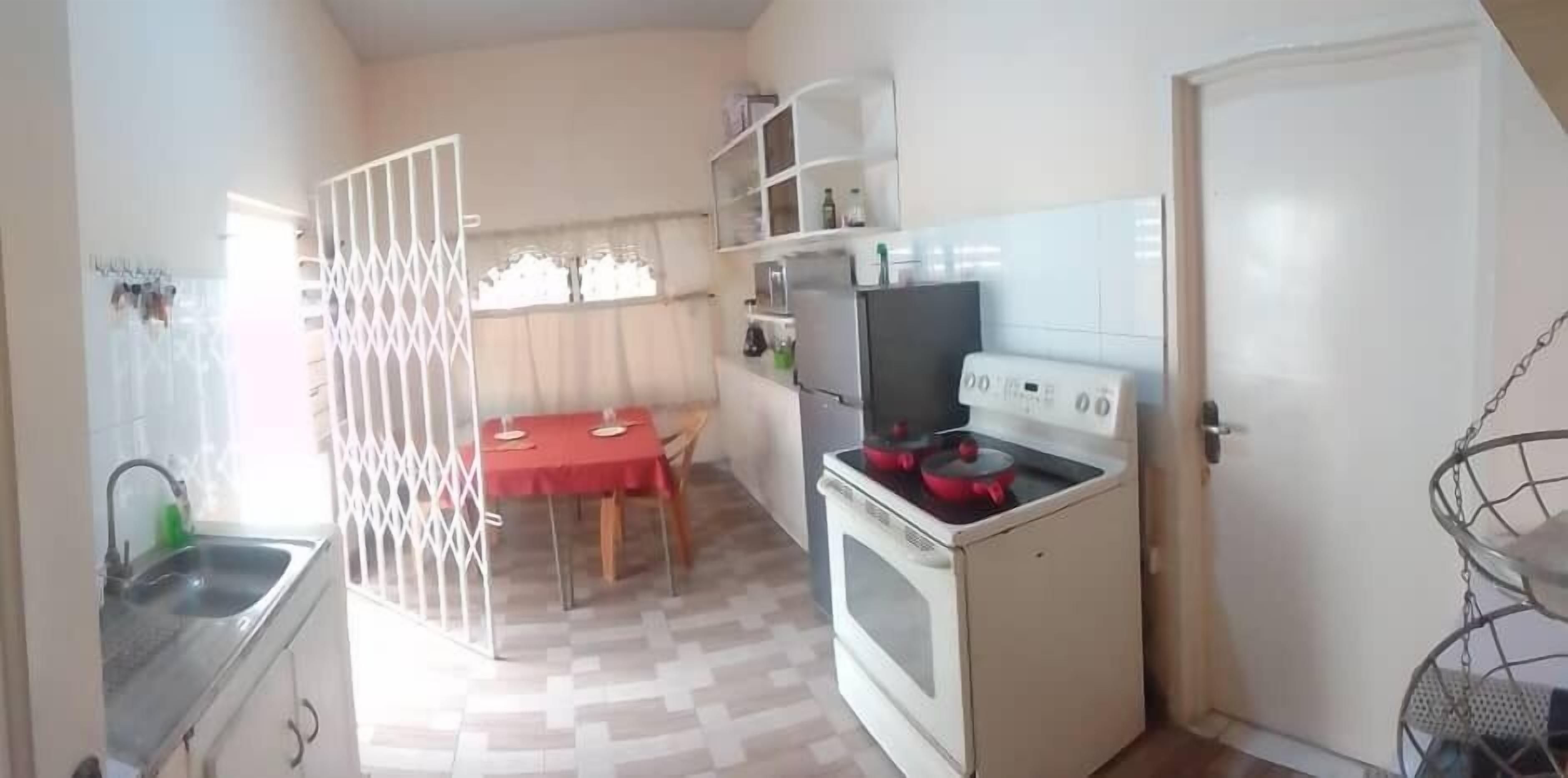 A compact kitchen with a stove, sink, and a dining table.