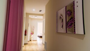 A hallway with a pink curtain, a fire extinguisher, and a vase with flowers. - Hostal Barcelona Travel (Barcelona)